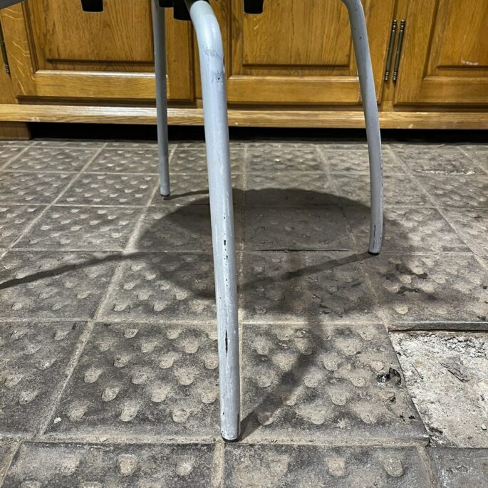 Zaļš plastmasas krēsls ar metāla kājām