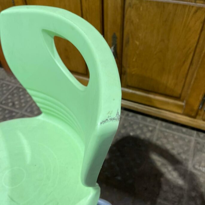 Zaļš plastmasas krēsls ar metāla kājām