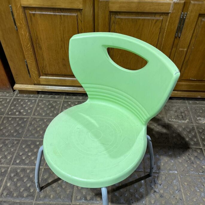 Zaļš plastmasas krēsls ar metāla kājām